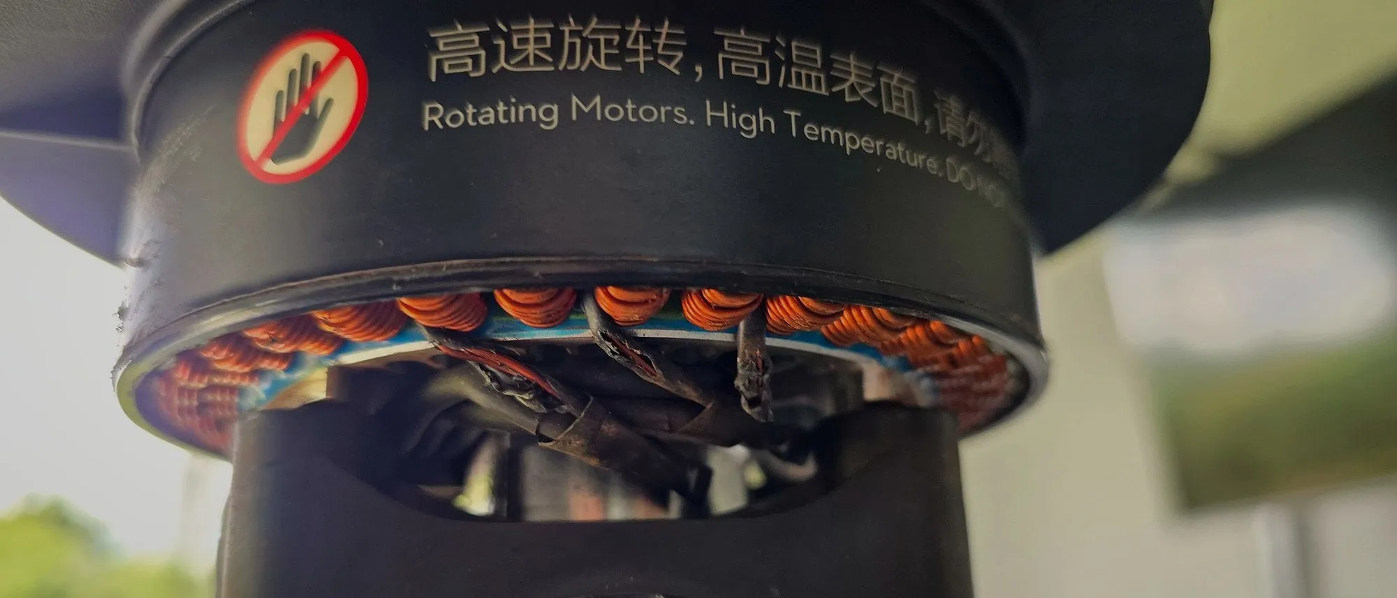 Motor de drone DJI Agras em close, com o aviso de motor giratório e superfície quente