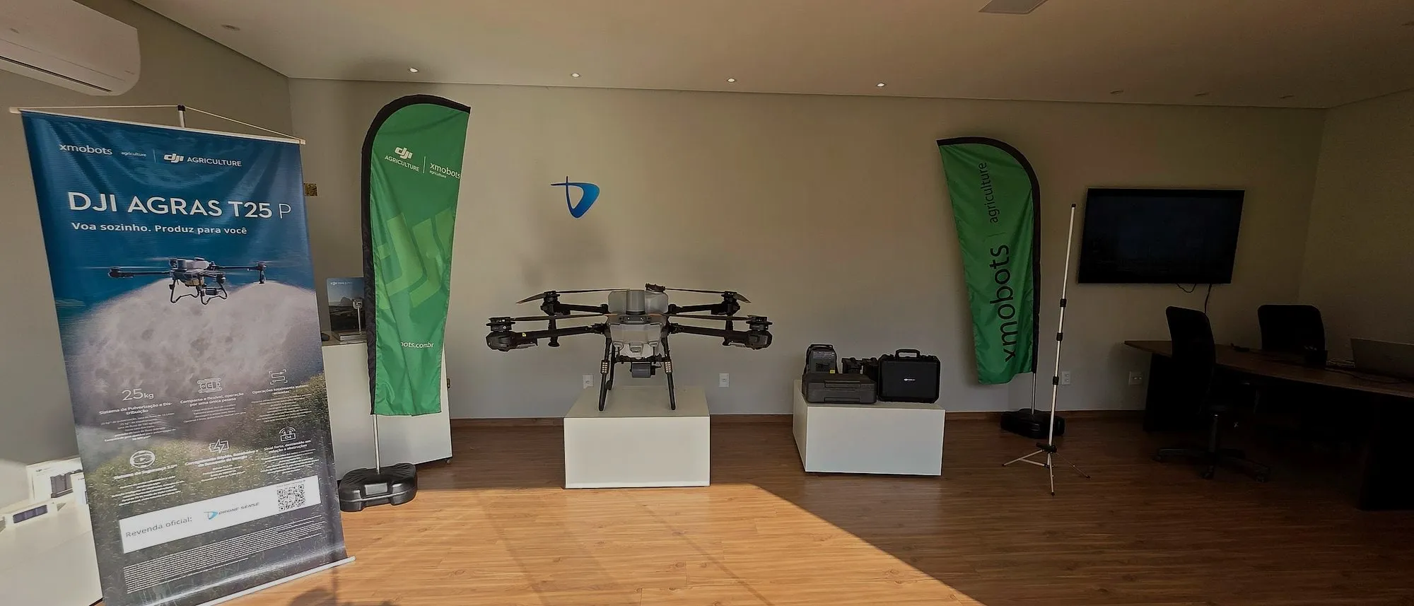 Showroom da Drone Sense com um drone DJI Agras exposto, o banner do T25P e a mesa de atendimento