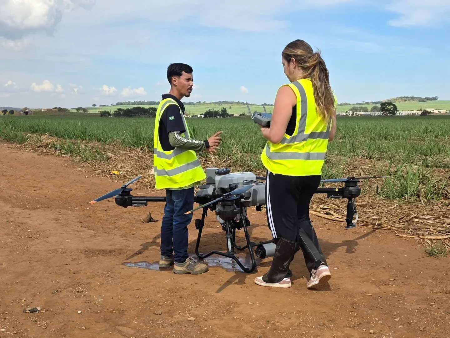 Atividade prática junto a um DJI Agras no campo, com um controle nas mãos